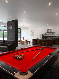 a living room with a red pool table at Stella Di Mare Puncak with Private Pool 5 Bedrooms in Sampal 2