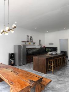 a kitchen with a wooden table and a refrigerator at Stella Di Mare Puncak with Private Pool 5 Bedrooms in Sampal 2