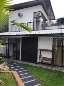 a house with a balcony and a bench on a walkway at Stella Di Mare Puncak with Private Pool 5 Bedrooms in Sampal 2