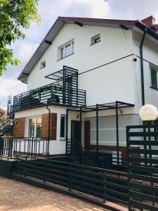 a white house with a black fence in front of it at Pokoje i Apartamenty Willa Bielany in Warsaw