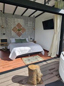 a bedroom with a bed and a tree stump in it at Equilibrium glamping in Guarne