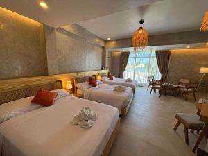 ein Hotelzimmer mit zwei Betten und einem Esszimmer in der Unterkunft Balay Isabel in San Juan