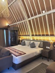 a bedroom with a large bed and a couch at Natuna Garden Villa in Ranai
