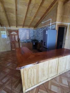 a kitchen with a wooden counter top and a refrigerator at Cabañas El Rincón De Huallerupe in Melipeuco