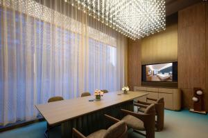 a conference room with a table and chairs and a television at Orange Crystal Hotel Wuhan Jinyinhu in Dongxihu