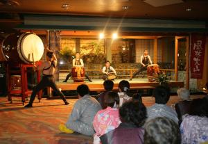 a group of people watching a band performing on a stage at Mt Fuji Hanayagi no Sho Keizan in Fuefuki