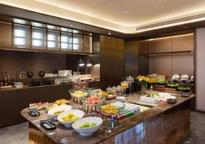 a kitchen with a counter with bowls of fruit on it at Orange Crystal Hotel Wuhan Jinyinhu in Dongxihu