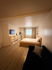 a bedroom with a bed and a tv and a couch at Garden and chill in Tijuana