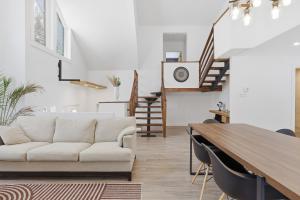 a living room with a white couch and a table at Private Forest Spa Retreat - Modern Chalet in Chertsey