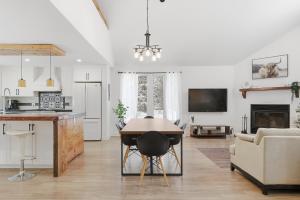 a kitchen and living room with a table and a couch at Private Forest Spa Retreat - Modern Chalet in Chertsey