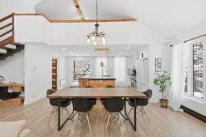 a kitchen and dining room with a wooden table and chairs at Private Forest Spa Retreat - Modern Chalet in Chertsey +15 photos