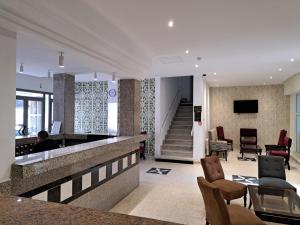 Die Lobby eines Hotels, in der eine Person an einer Bar sitzt. in der Unterkunft Hôtel Ennassim in Sousse