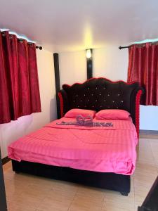 a bedroom with a bed with pink sheets and a ribbon at พีเจ คิงดอม โฮมสเตย์ in Buriram