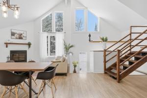 a white living room with a wooden table and stairs at Private Forest Spa Retreat - Modern Chalet in Chertsey