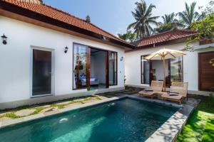 a villa with a swimming pool and a house at Umah Uwa Villa Ubud in Tegalalang