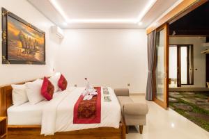 a bedroom with a white bed and a chair at Umah Uwa Villa Ubud in Tegalalang +32 photos