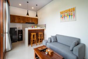 a living room with a blue couch and a table at Umah Uwa Villa Ubud in Tegalalang