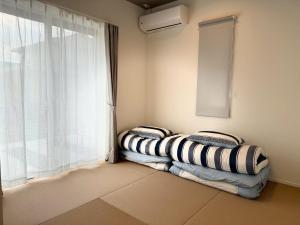 two beds in a room with a window at Akikawa Koshi 12 プレミアム木造 一棟貸切ヴィラ in Yuge
