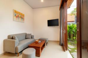 a living room with a couch and a tv at Umah Uwa Villa Ubud in Tegalalang