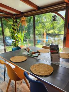 a dining room table with chairs and a large window at Chez Nirina proche Puys DuFou in Mortagne-sur-Sèvre +24 photos