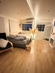 a living room with a couch and two windows at Casita Garden n chill in Tijuana