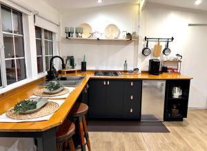 a kitchen with a sink and a counter with stools at Casita Garden n chill in Tijuana