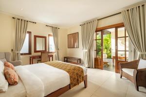 a bedroom with a bed and a desk and a chair at Villa Balidamai in Kerobokan +85 photos