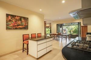 a kitchen and dining room with a painting on the wall at Villa Balidamai in Kerobokan