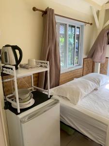 a room with a bed and a table with dishes on it at Pink Kangaroo Bungalows in Ko Kood