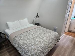 a bedroom with a bed with a white bedspread at Stylish Cabin Escape w - Kitchenette & Ensuite Bath in Port Renfrew