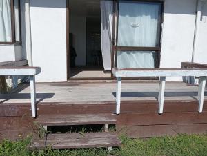 an open door of a house with a bench on a porch at Budget accommodations 2 in Papamoa