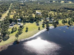an aerial view of a lake with trees and houses at Cheap Rooms North Brisbane in Narangba