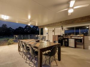 a kitchen and dining room with a wooden table and chairs at Cheap Rooms North Brisbane in Narangba