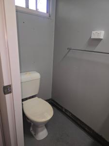 a white toilet in a bathroom with a window at Cheap Rooms North Brisbane in Narangba