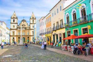 a group of people sitting at tables on a city street at Marlon Franca in Salvador