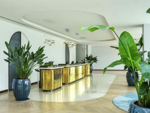 a lobby with potted plants and a row of counters at Rixos Premium Dubrovnik in Dubrovnik