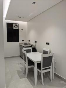 a kitchen with a white table and chairs in a room at فندق بوابة ابها in Khamis Mushayt +8 photos