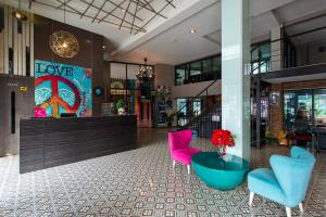 a lobby with pink and blue chairs and a counter at BB House Khlong Tan บีบีเฮ้าส์ คลองตัน in Bangkok +7 photos