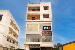 a tall white building with a sign on it at Hotel O The Crown in Kolkata