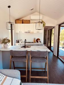 a kitchen with a sink and two bar stools at Hilltop Haven Darlington in Darlington