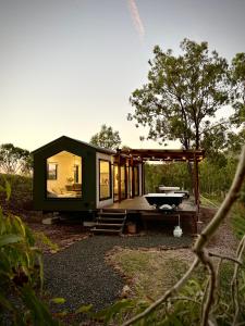 a green tiny house sitting on top of a field at Hilltop Haven Darlington in Darlington +11 photos