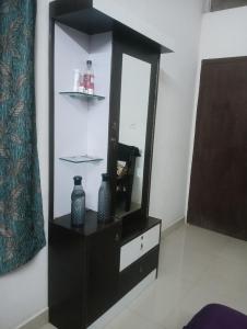 a black dresser with a mirror and vases on it at Rajwaniya home in Jaipur