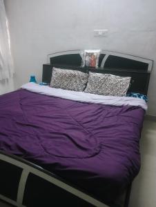 a bed with purple sheets and pillows on it at Rajwaniya home in Jaipur