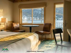 a bedroom with a bed and two chairs and a table at Western Riviera Lakeside Lodging in Grand Lake