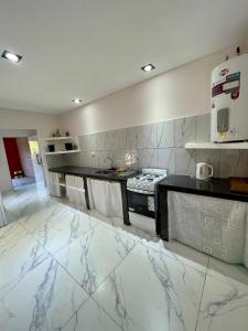 a kitchen with white marble flooring and a stove at Las Mariposas in Merlo