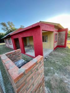 a house with a brick wall in front of it at Las Mariposas in Merlo