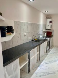 a kitchen with a black counter and a sink at Las Mariposas in Merlo +27 photos