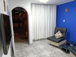 a living room with a chair and a television at Van Gogh Duitama in Duitama