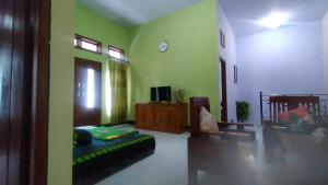 a living room with a couch and a tv at mas dylan homestay in Probolinggo