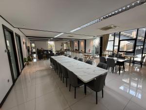 a dining room with a long table and chairs at Flamingo Homestay Port Dickson in Port Dickson